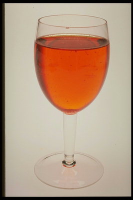 Un vaso de vino tinto de color naranja