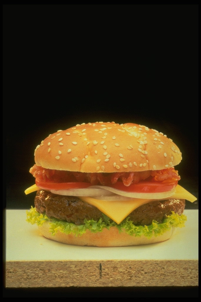 Чизбургер с сочной котлетой с мяса, ломтиком сыра, и овощами