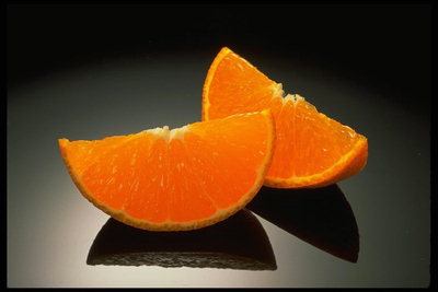 Кусочки сочного апельсина на черном фоне