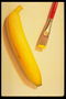 Банан и кисть с желтой краской