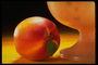 Персик с маленьким листком на фоне вазы