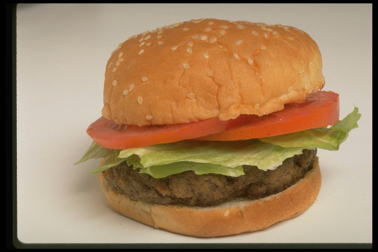 Чизбургер с мясной котлетой, листьми салата, помидором