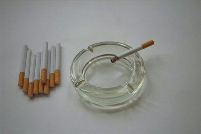 Стеклянная пепельница, пара сигарет с фильтром