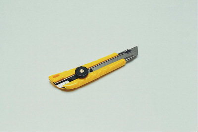 Канцелярский ножик с желтой пластмассовой ручкой