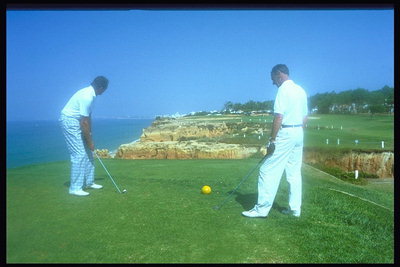 Два мужчины играют в гольф