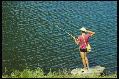 Парень ловит рыбу в речке  