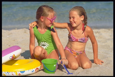 Две девочки гуляют в песочке возле моря