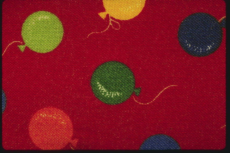 Разноцветные воздушные шарики на красной ткани