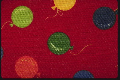Разноцветные воздушные шарики на красной ткани