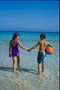 Meisje en jongen met de bal lopen op het strand
