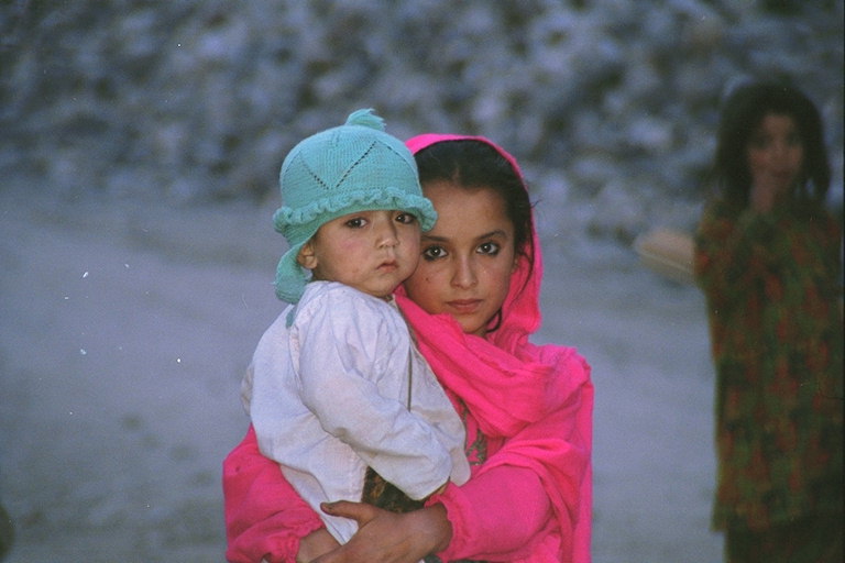 The girl in the pink khăn với một cậu bé ở tay