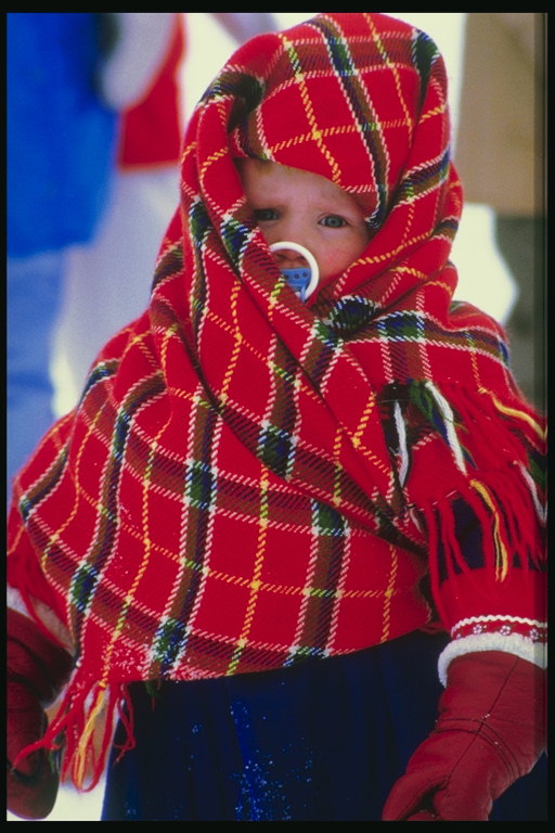 Un băieţel în checkered eşarfă înfofolit