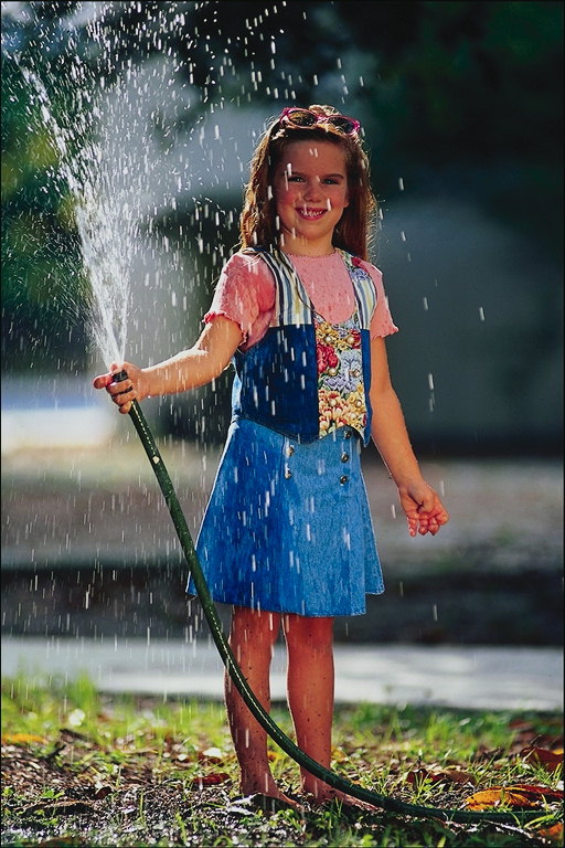 Девочка держит шланг с водой
