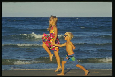 Dievča a chlapec prechádzky popri mori