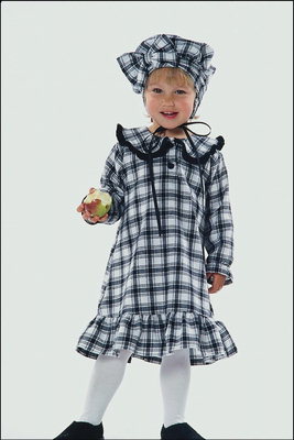 Jeune fille en costume, dans la case mange une pomme