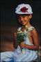 La petite fille dans un chapeau et des fleurs