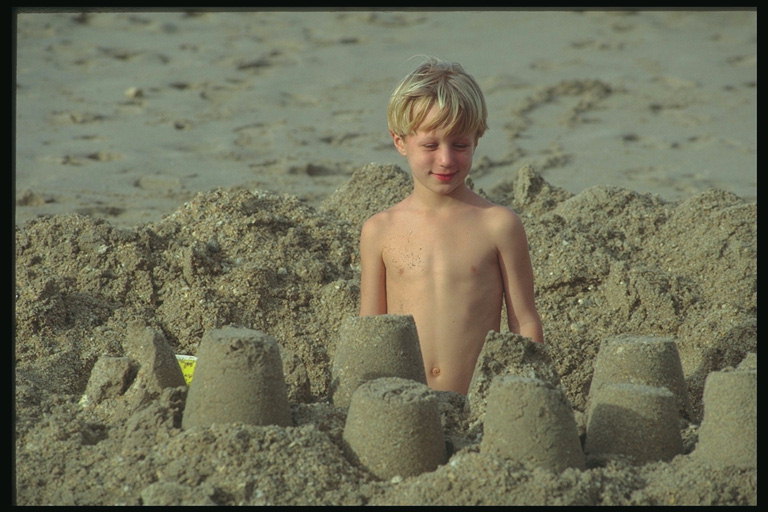 Boy makes with the sand castle