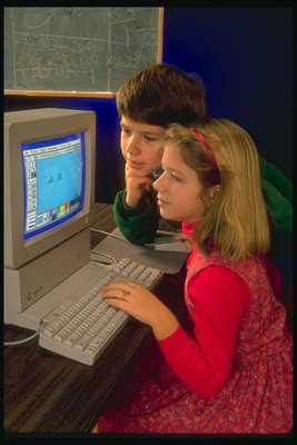 लड़की को एक कंप्यूटर करने के लिए अगले के साथ लड़का