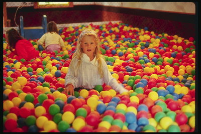 Девочка среди разноцветных шаров