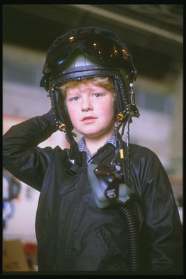 O rapaz, no capacete de piloto