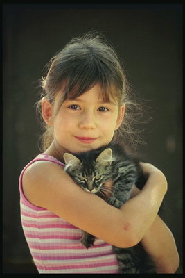 Meitene ar tumšiem pelnu pelēks котом