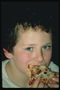 Мальчик кушает пиццу