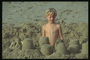 Мальчик делает замок с песка