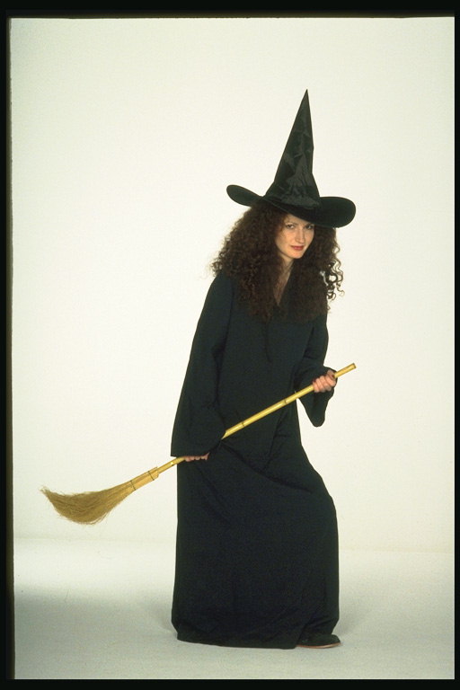 Женщина в костюме ведьмы. С колпаком и с метлой