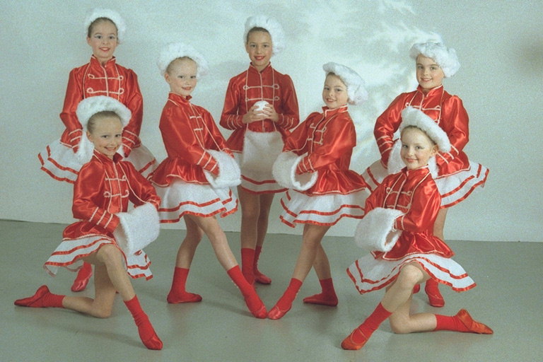 Girls in red and white costumes. In the white hats, and clutches