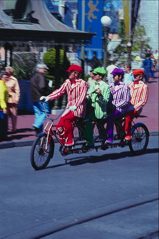 Мужчины в полосатых костюмах на велосипеде