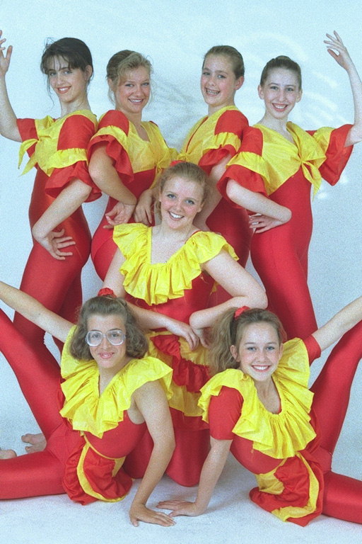 Meitenes ar sarkanu kleitu ar dzeltenām apkakle