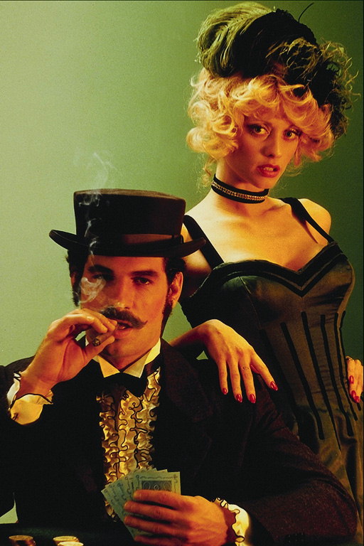 Một phụ nữ trong một corset. Một người đàn ông trong buổi tối ăn mặc và một cigar