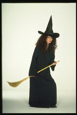 Kadın cadı kostümü içinde. Bir kapak ile ve bir süpürge ile
