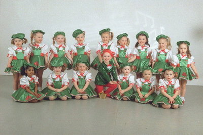 Små flickor i gröna klänningar och vita blus