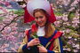 Dívka v kostýmu v klobouku s červenou tulipánů v rukou