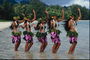 समुद्र तट पर हवाईयन वेशभूषा में नृत्य