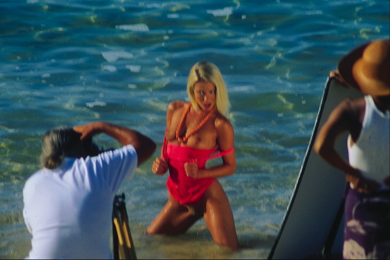 해변에있는 슈팅. 빨간 옷을 입고 있던 여자