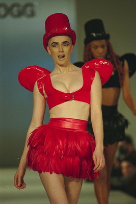 Девушка в красном костюме.  Кожанный корсет с крыльями. Юбка с перьями