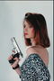 En pige i en kjole med en pistol i hænderne på