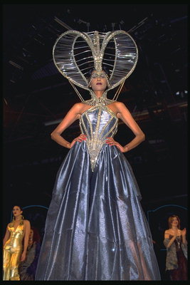 Dunkel-lila Kleid mit Metall Glanz. Großer Hut mit Steinen