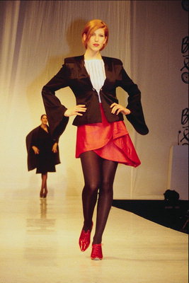 Falda roja con bordes irregulares. Chaqueta de color marrón oscuro