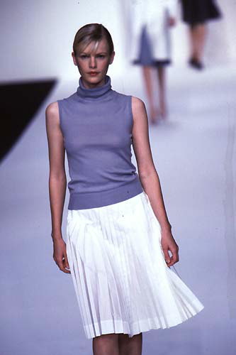 The white skirt in the small folds and lilac golf with short sleeves