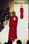 लाल satiny पोशाक और लंबी लाल कोट drapovoe