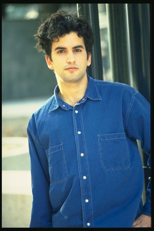 नीली कमीज में एक जवान आदमी