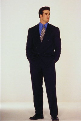 Un tânăr într-un costum negru şi cămaşă albastră