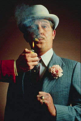 A man in a hat smoking cigar