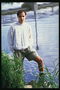 A mladý kluk v krátkých filmů stojí ve vodě v blízkosti pobřeží