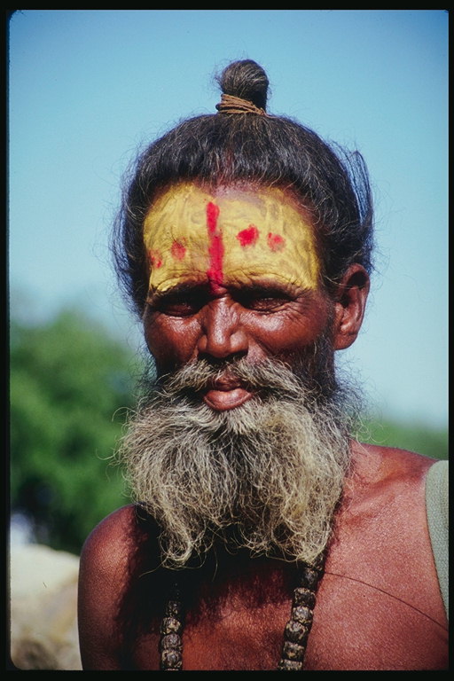 चेहरे पर एक पैटर्न के साथ बुजुर्ग आदमी