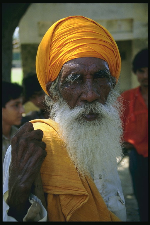 Morfar i orangefärgade turbaner och vit skjorta