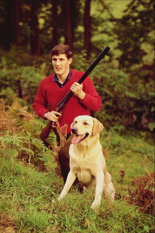 Un home cunha arma e can